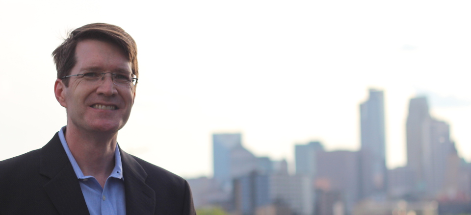 Brian Hagerty, a candidate for Hennepin County District Judge, in front of Minneapolis skyline, June 2014